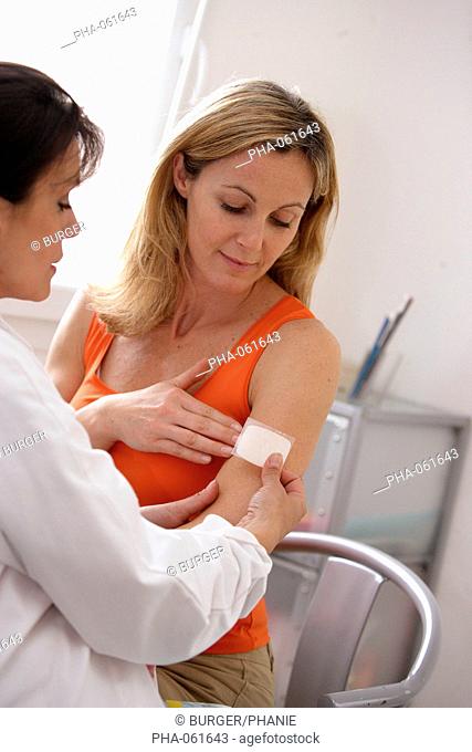 A doctor explains a 40 years old female patient the use of the oestrogen patch used in a Hormone Replacement Therapy