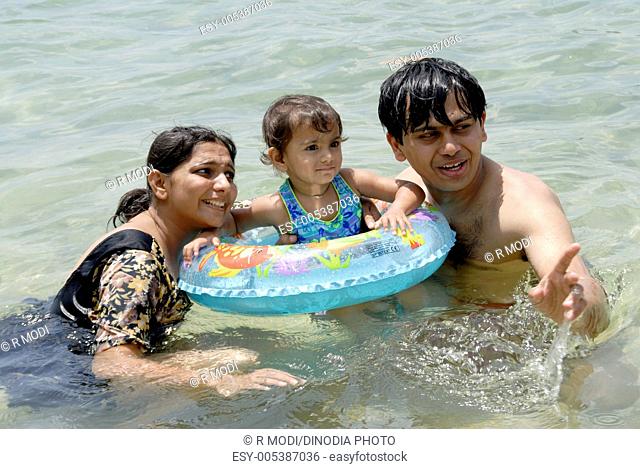 Parents and two year old baby girl enjoying swimming in Wadoor beach ; South Andaman Islands ; Bay of Bengal ; India MR 736J;736K;736L October 2008