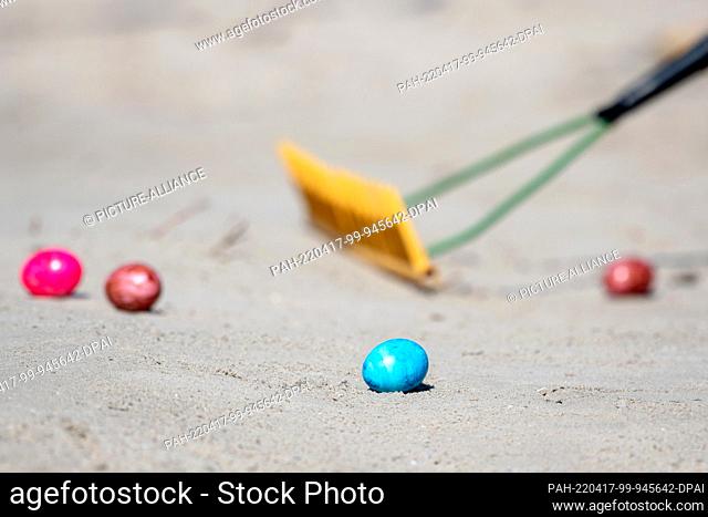 17 April 2022, Lower Saxony, Norderney: Colorful Easter eggs lie in the sand on Easter Sunday during the traditional ""Eiertrullern"" on the island's western...