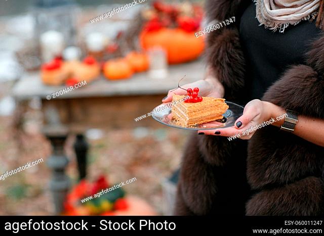 halloween inspiration. cake in hands. Autumn still life. pumpkin, dry roses, viburnum honey cake. Honey in a vase. dry twigs. on the table