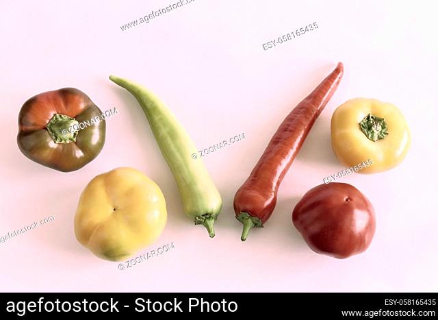 On a light background, six bell peppers of different colors and shapes