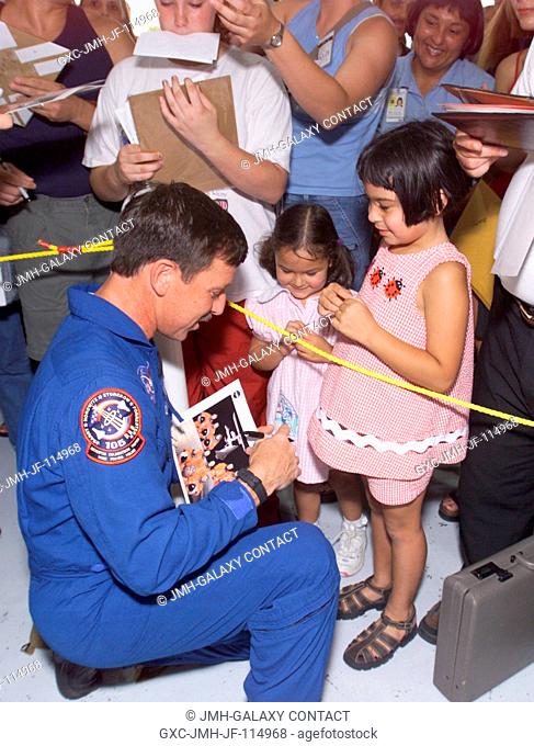 Scott J. Horowitz, STS-105 commander, signs an autograph for two young visitors in Hangar 990 at Ellington Field during the STS-105 and Expedition Two crew...