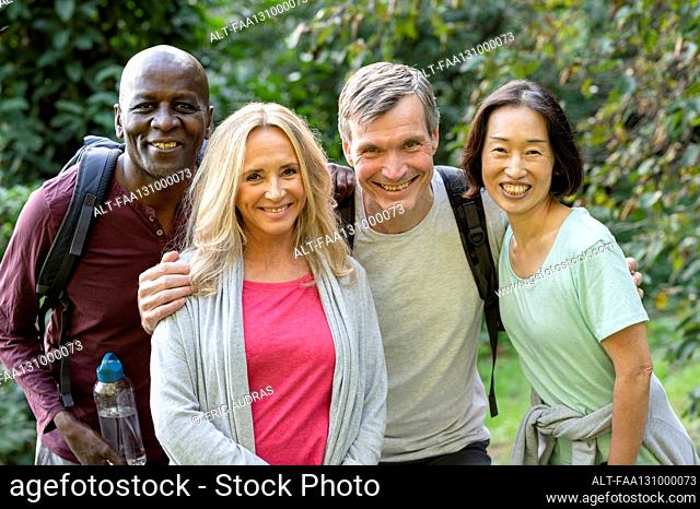 Two diverse senior couples enjoying a walk out in the woods