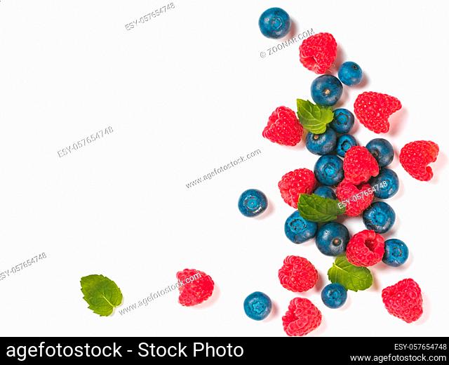Various fresh summer berries background with copy space for text.Creative layout of fresh blueberries, raspberries and mint leaves