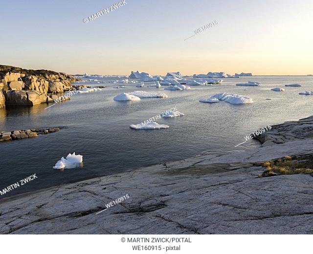 Coastal landscape with Icebergs. The Inuit village Oqaatsut (once called Rodebay) located in the Disko Bay. America, North America, Greenland, Denmark