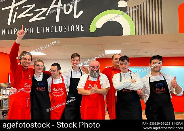 PRODUCTION - 22 June 2023, Italy, Monza: Nico Acampora (M), founder of the project and restaurant, and his team of waiters and pizza makers from the restaurant...
