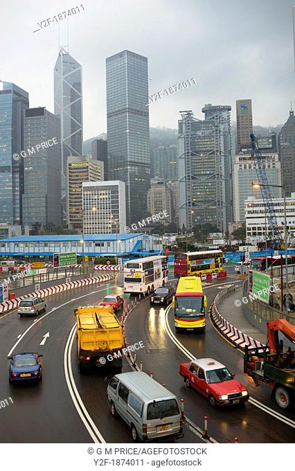 cars, buses and trucks with Hong Kong skyline at Central