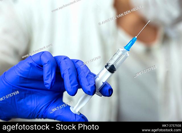 Doctor, nurse, scientist hand in blue gloves holding flu, measles, coronavirus, covid-19 vaccine disease preparing for child, baby, adult