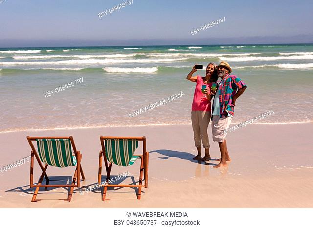 Senior couple taking selfie with mobile phone on beach