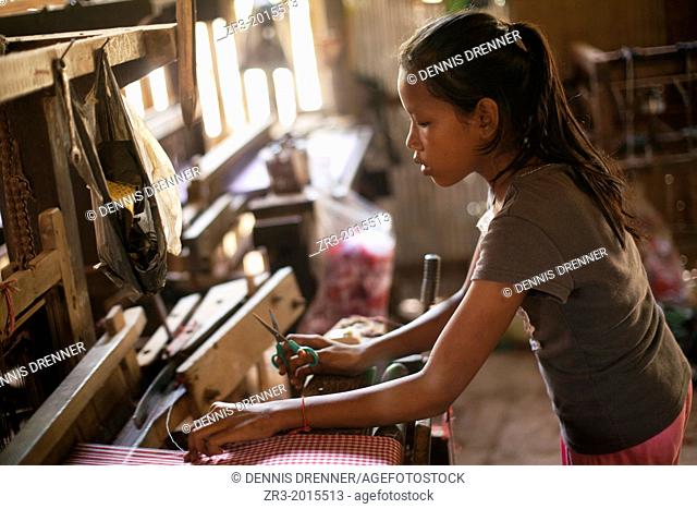 A young girl works in a village textile factory outside of Phnom Penh, Cambodia