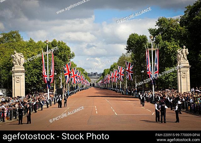14 September 2022, Great Britain, London: Police officers stand on the edge of the street ""The Mall"" in front of waiting spectators before the start of the...
