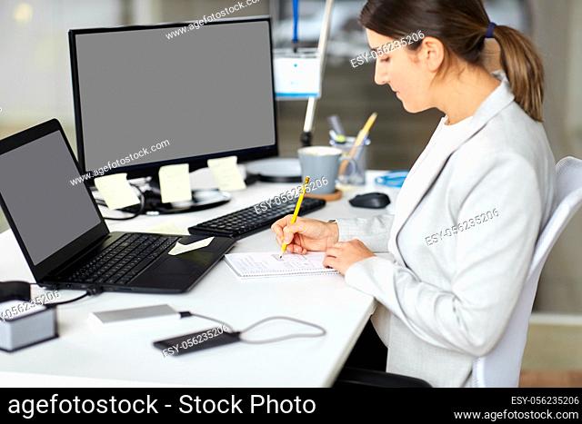 businesswoman with notebook and laptop at office