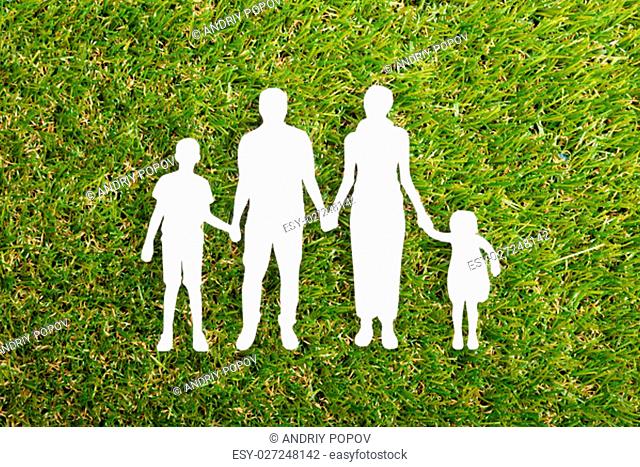 High Angle View Of Family Papercut On Grass