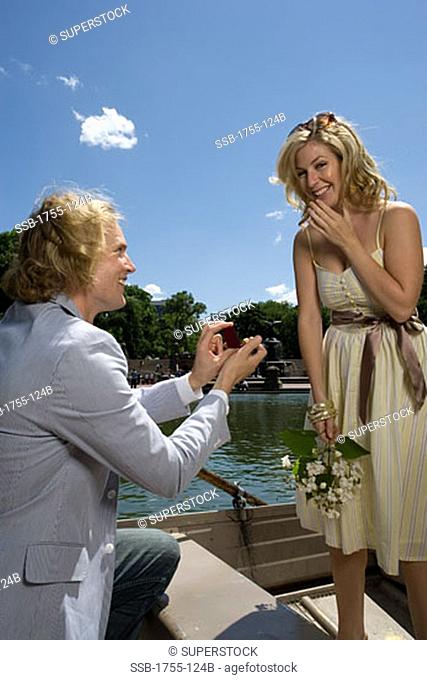 Young man proposing to a young woman and smiling, Central Park, Manhattan, New York City, New York, USA