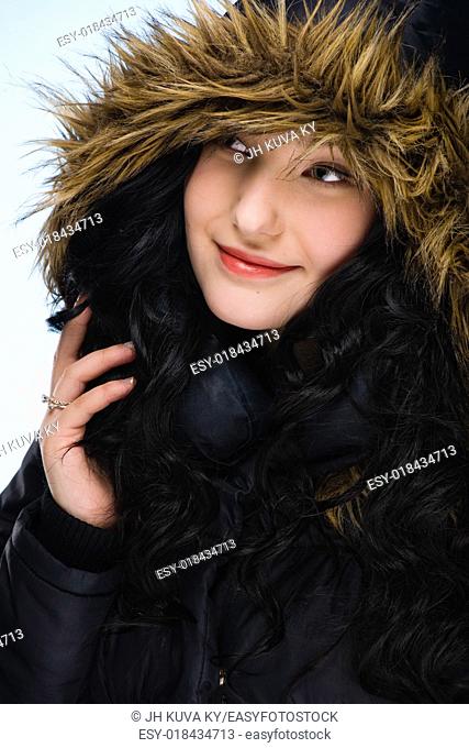 Beautiful girl wearing hood, light blue background, vertical format