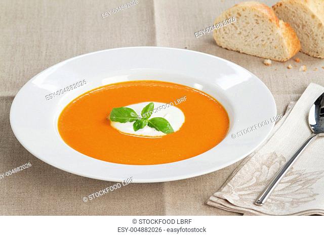 Cream of tomato soup garnished with a dollop of creme fraiche and basil