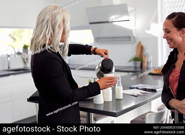 Estate agent pouring coffee to client