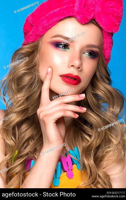 Bright cheerful girl in a home hat, colorful make-up, curls and pink manicure. Beauty face. Photo taken in the studio