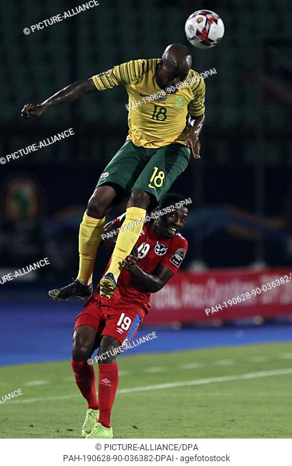 28 June 2019, Egypt, Cairo: South Africa's Sifiso Hlanti (L) and Namibia's Petrus Shitembi battle for the ball during the 2019 Africa Cup of Nations Group D...