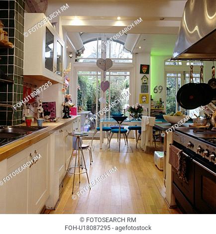 Wooden flooring in large galley kitchen and dining room with French doors to courtyard garden