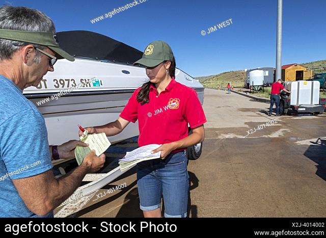 Evanston, Wyoming - An employee of the Wyoming Game & Fish Department gives a boat owner a receipt after inspecting and decontaminating the watercraft at a...