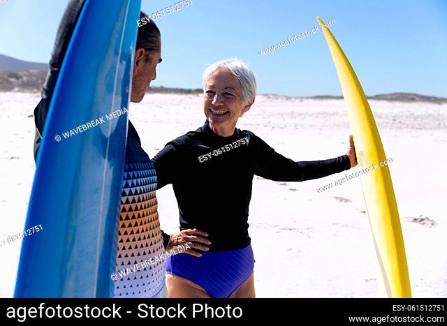 Senior Caucasian couple holding surfboards at the beach