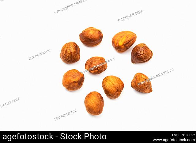 a scattered brown hazelnut on white background