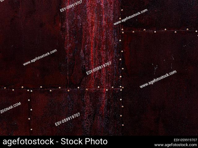 Close up dark burgundy texture color metal background with small rivets, sheet of rusty iron grunge backdrop, metallic surface, design with copyspace