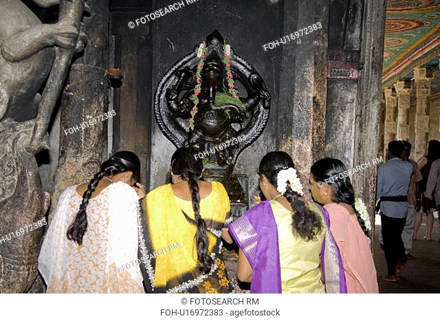 Female worshippers praying in front of a Ganesh shrine, Meenakshi Temple, Madurai, Tamil Nadu, India