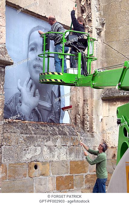 POSTING OF THE GIANT PHOTOS WITH AN AERIAL LIFT ON THE WALLS OF THE TOWN FOR THE RUGL'ART CULTURAL FESTIVAL, RUGLES, (27) EURE, FRANCE