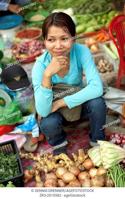 Portrait of a young woman vegetable vendor at a marketplace in Phnom Penh, Cambodia