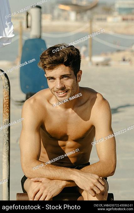 Young handsome men portrait exercising at the beach
