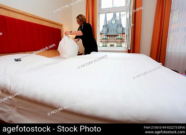 27 May 2021, Saxony-Anhalt, Wernigerode: Doreen Wieland prepares a room at the Hotel Weißer Hirsch before the reopening. Among other industries