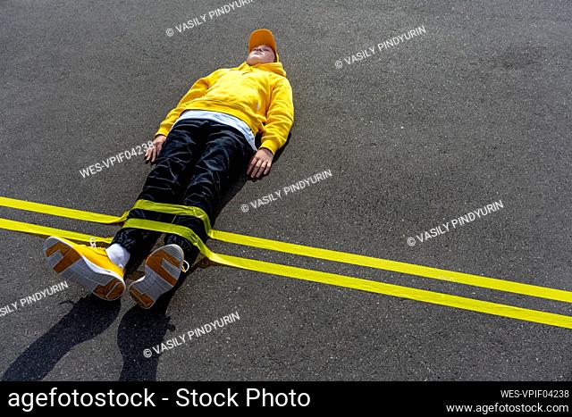 Yellow adhesive tape marking over boy lying on road