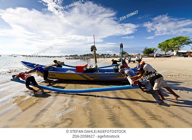 Muslim Fishermen pushing their Boat to the Water in Jimbaran on Bali, Indonesia