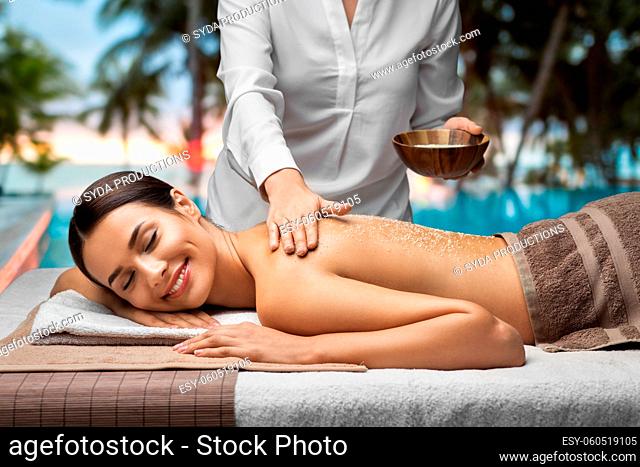 beautiful young woman having salt massage at spa