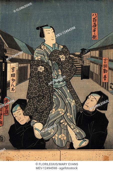 Puppet in kimono being manipulated by two bunraku puppeteers in black robes. Woodblock ukiyo-e print by Utagawa Kunisada II, Tokyo, 1850s