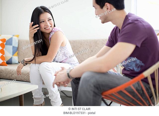 Smiling woman talking to husband in living room