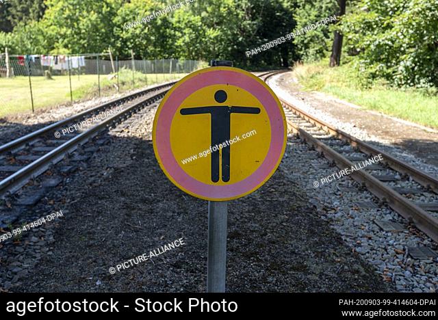 03 August 2020, Mecklenburg-Western Pomerania, Garftitz: At the Garftitz railway station, a sign warns against stepping on the tracks