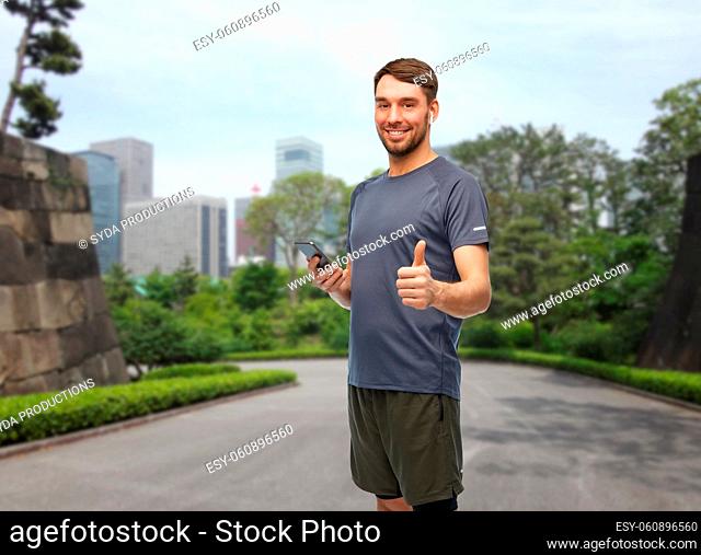 man in sports clothes with phone and earphones