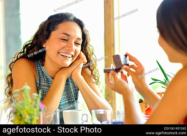 Marriage proposal of two happy lesbian women in a restaurant