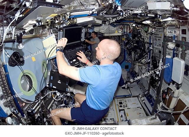 Astronaut Clay Anderson, STS-120 mission specialist, uses a computer in the Destiny laboratory of the International Space Station while Space Shuttle Discovery...