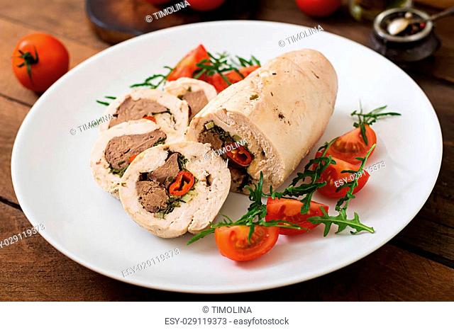 Diet baked chicken rolls stuffed liver, chili and herbs with a salad of tomatoes and arugula. Dietary menu. Proper nutrition