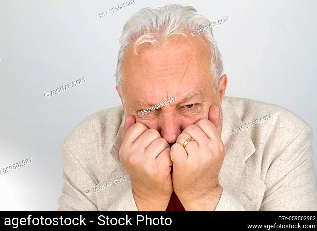 Senior hält Hände vor Mund - auf hellem Hintergrund