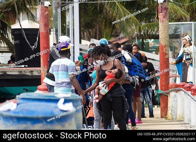 Migrants do long lines to board a boat as thousands of Haitian, African and Cuban migrants that came from Chile, Brazil or Suriname