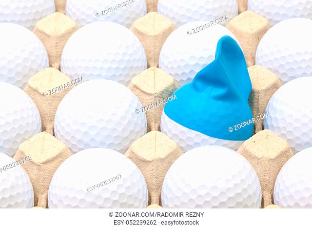 White golf balls in the box for eggs. Golf ball with funny cap.Funny golf concept