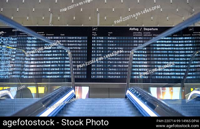 14 July 2022, Lower Saxony, Hanover: An escalator leads to a display panel in Terminal A at Hannover Airport. In Lower Saxony