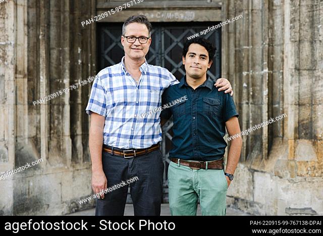 PRODUCTION - 13 September 2022, Lower Saxony, Brunswick: Gerd-Peter Münden (l) and his husband Esteban Builes-Münden stand in front of Braunschweig Cathedral