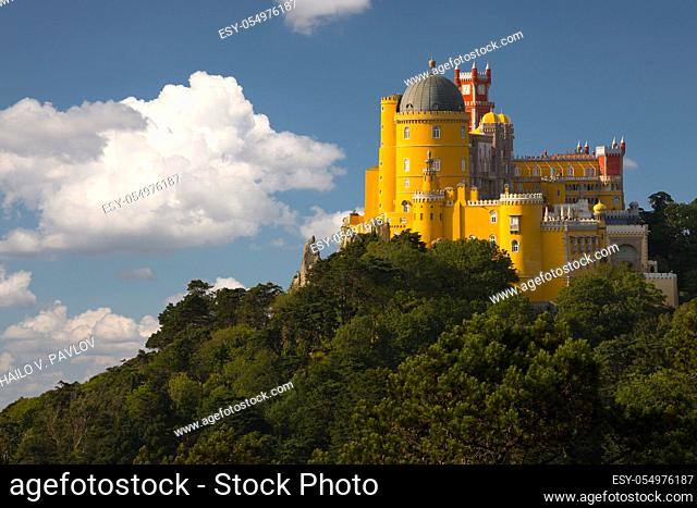 Portugal. Sintra. The Pena Palace on a cliff surrounded by forest and clouds