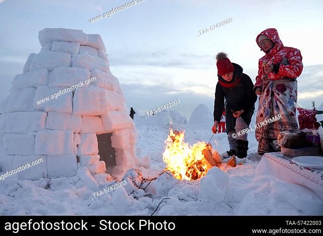 RUSSIA, NOVOSIBIRSK - FEBRUARY 18, 2023: People take part in an igloo building competition at the Igloo 2023 Eskimo Town winter festival in U Morya Obskogo [By...